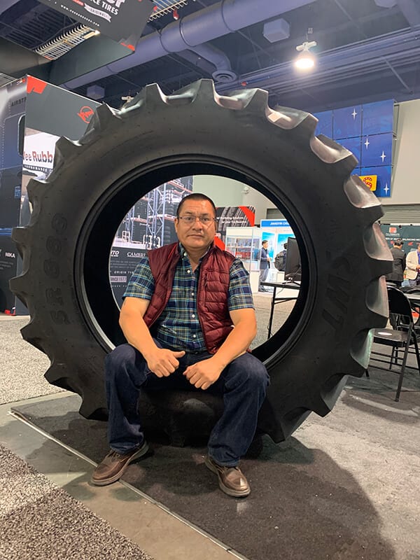 José Luis Sánchez, dueño de Michoacan Auto, sentado dentro de una llanta de tractor en una exhibición